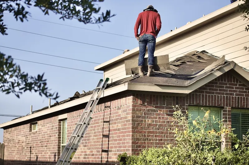Professional roofer working on a residential roof in Raisinville